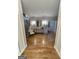 Hallway with hardwood floors leading to multiple rooms. Includes staircase and chair at 125 Sir Lancelot Ct, Fayetteville, GA 30214