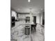 Spacious kitchen with white cabinets, stainless steel appliances, marble countertops, and an island with bar stools at 125 Sir Lancelot Ct, Fayetteville, GA 30214