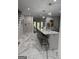 Bright kitchen island with seating, marble floors and countertops, and modern pendant lights at 125 Sir Lancelot Ct, Fayetteville, GA 30214