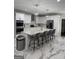 Large kitchen with white cabinets, stainless steel appliances, marble countertops and island with seating and lighting at 125 Sir Lancelot Ct, Fayetteville, GA 30214