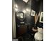 Elegant black powder room with a vessel sink, hexagon floor tiles, and unique gold-toned sconces at 125 Sir Lancelot Ct, Fayetteville, GA 30214