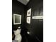 Modern black powder room with picture frame molding, unique fixtures, and a monochromatic design at 125 Sir Lancelot Ct, Fayetteville, GA 30214