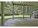 Covered back porch with a concrete floor and view of the wooded backyard at 118 Whitfield Run, Peachtree City, GA 30269