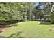 Expansive backyard featuring a large, grassy area surrounded by dense trees at 118 Whitfield Run, Peachtree City, GA 30269