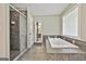 This bathroom features a glass enclosed shower and a soaking tub with tiled surround at 118 Whitfield Run, Peachtree City, GA 30269