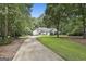 A house with a long driveway surrounded by trees, enhancing its curb appeal and natural setting at 118 Whitfield Run, Peachtree City, GA 30269