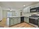 Bright eat-in kitchen with stainless steel appliances and breakfast bar that opens to a view of the living room at 118 Whitfield Run, Peachtree City, GA 30269