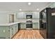 Well-equipped kitchen with green cabinets, stainless steel appliances, and plenty of counter space for cooking at 118 Whitfield Run, Peachtree City, GA 30269
