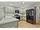 Modern kitchen with green cabinets, quartz countertops, and stainless steel appliances, ideal for culinary enthusiasts at 118 Whitfield Run, Peachtree City, GA 30269