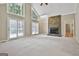 Spacious living room featuring a stone fireplace, large windows, and ample natural light at 118 Whitfield Run, Peachtree City, GA 30269