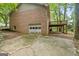 Rear exterior view of the house, showing a brick facade, elevated deck, and garage door at 1290 Shadowlawn Ne Dr, Conyers, GA 30012
