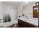Bathroom with tile flooring, shower-tub combo, dark wood cabinet, mirror and white sink at 1290 Shadowlawn Ne Dr, Conyers, GA 30012