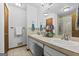 Bathroom featuring double sinks, neutral tile counter, large mirror and a shower-tub combo at 1290 Shadowlawn Ne Dr, Conyers, GA 30012