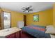Bedroom with bright yellow walls, ceiling fan, desk and attached bathroom at 1290 Shadowlawn Ne Dr, Conyers, GA 30012