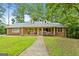 Charming brick home featuring a quaint front porch, two dormers, and a well-manicured front lawn at 1290 Shadowlawn Ne Dr, Conyers, GA 30012