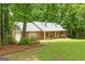 Charming brick home featuring a well-manicured lawn and inviting front porch, shaded by mature trees at 1290 Shadowlawn Ne Dr, Conyers, GA 30012