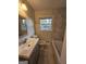 Bathroom featuring marble tiled walls, a modern vanity, toilet, and a bathtub with shower at 655 Shellnut Dr, Forest Park, GA 30297