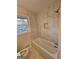 Updated bathroom with marble tile, shower, and natural light from the window at 655 Shellnut Dr, Forest Park, GA 30297