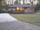 Inviting home with a spacious driveway and a charming wooden deck overlooking the well-manicured front lawn at 655 Shellnut Dr, Forest Park, GA 30297