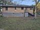 View of brick home featuring a rear entrance with stairs and a partial basement foundation at 655 Shellnut Dr, Forest Park, GA 30297