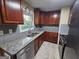 Bright kitchen showcasing updated stainless appliances, dark cabinets, and stone countertops at 655 Shellnut Dr, Forest Park, GA 30297