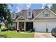 Traditional home with dormer windows, a two-car garage, green shutters, and a landscaped front yard at 221 Turtle Cv, Carrollton, GA 30116