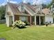 Charming home featuring beautiful landscaping, a brick accent wall, and a well-manicured lawn at 221 Turtle Cv, Carrollton, GA 30116