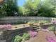 Landscaped backyard featuring retaining wall, flowers, and wooden privacy fence at 221 Turtle Cv, Carrollton, GA 30116