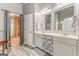Well-lit bathroom with a double vanity, contemporary design elements, and doorway to a walk-in closet at 119 Creekside Vw, Hiram, GA 30141