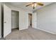 Bedroom features neutral walls, carpet, a ceiling fan, and doorways to the closet and hallway at 2898 Cedar Trace Dr, Ellenwood, GA 30294