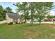 Residential home featuring a lush green lawn, mature trees, and manicured bushes along the front at 2898 Cedar Trace Dr, Ellenwood, GA 30294