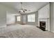 Spacious living room boasts a ceiling fan, fireplace, large windows, and plush carpeting at 2898 Cedar Trace Dr, Ellenwood, GA 30294