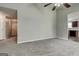 Open-concept living room with plush carpeting, ceiling fan, and doorways to the kitchen and foyer at 2898 Cedar Trace Dr, Ellenwood, GA 30294