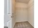 This walk-in closet offers metal shelving, white walls and neutral carpet flooring for storage and organization at 2898 Cedar Trace Dr, Ellenwood, GA 30294