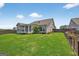 View of the home's backyard with a covered patio and green lawn at 4160 Grandview Vista St, Cumming, GA 30028