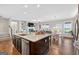 Modern kitchen flows to breakfast area, island with granite countertop and stainless steel dishwasher at 4160 Grandview Vista St, Cumming, GA 30028