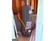 A gray Rheem water heater stands against a wood wall with white doors next to it at 133 Magazine St, Dallas, GA 30157