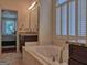 Bright bathroom with marble countertops, double vanity, jacuzzi tub, and plantation shutters at 183 Eagles Club Dr, Stockbridge, GA 30281