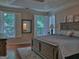 Cozy main bedroom with hardwood floors and plantation shutters with an ensuite bathroom at 183 Eagles Club Dr, Stockbridge, GA 30281