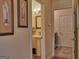 Hallway view of powder room featuring a pedestal sink and decorative mirror at 183 Eagles Club Dr, Stockbridge, GA 30281