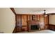 Cozy living room featuring wood paneling, a ceiling fan, a decorative brick fireplace, and a wall clock at 3626 Lone Indian Trl, Marietta, GA 30066