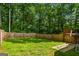 Expansive backyard with green lawn, wooden fence, and wooded surroundings at 1048 Falls Brooke Dr, Conyers, GA 30094