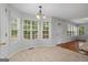 Sunny breakfast nook features large windows, stylish chandelier, and access to exterior door at 1048 Falls Brooke Dr, Conyers, GA 30094