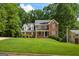Charming two-story brick home with a well-manicured lawn and mature trees creating a serene setting at 1048 Falls Brooke Dr, Conyers, GA 30094