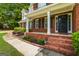 Inviting brick front porch with white columns and a well-kept lawn, enhancing curb appeal at 1048 Falls Brooke Dr, Conyers, GA 30094