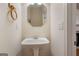 Powder room featuring a pedestal sink and an elegant octagon-shaped mirror at 10775 Brunson Dr, Johns Creek, GA 30097