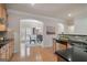 Open kitchen with wood cabinets and black countertops, seamlessly connected to the adjacent dining area at 10775 Brunson Dr, Johns Creek, GA 30097