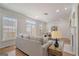 Bright living room featuring large windows, neutral-toned furnishings, and hardwood flooring at 10775 Brunson Dr, Johns Creek, GA 30097