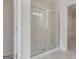 Modern glass enclosed shower near walk-in closet, with tile flooring in bathroom at 10775 Brunson Dr, Johns Creek, GA 30097