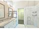 Bright bathroom featuring a double sink vanity, wall mirror, glass enclosed shower, and access to walk-in closet at 4107 Township Pkwy # 69, Sandy Springs, GA 30342